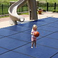 girl standing on pool cover with ball