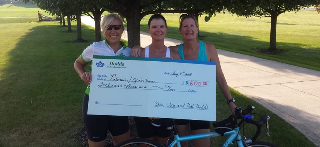 3 ladies smiling and holding check
