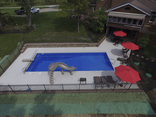 Inground fiberglass pool with handrail and deck accessories