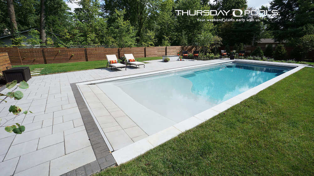 Installed Grace Beach Entry fiberglass pool with walk-in shallow entry and paver deck
