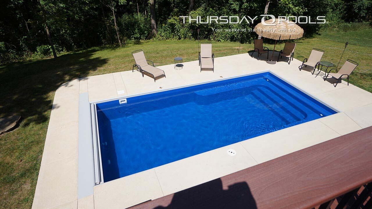 Installed Lil Bob fiberglass pool with automatic cover and concrete deck