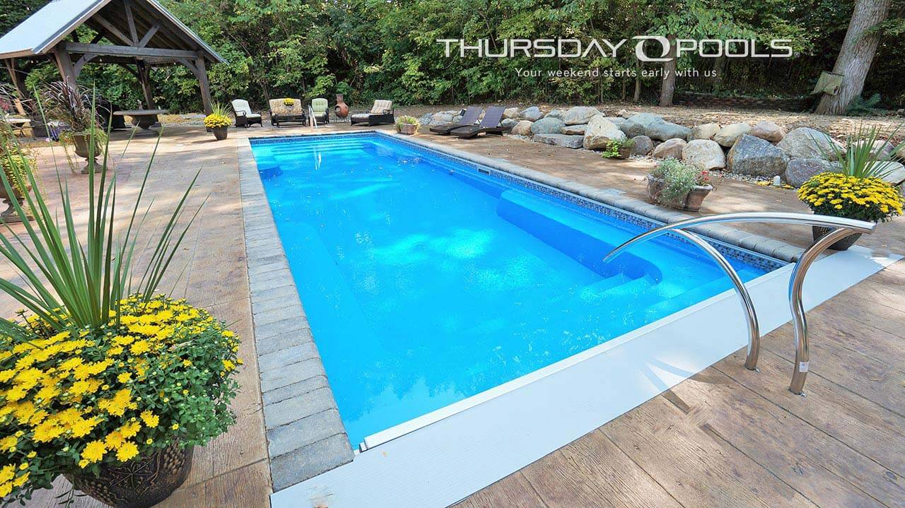 Installed Spirit fiberglass pool with automatic cover and stamped concrete deck