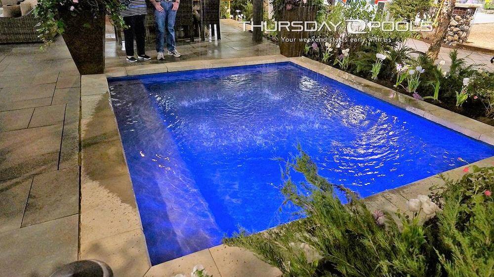 Installed fiberglass wading pool with bench seat and stone coping