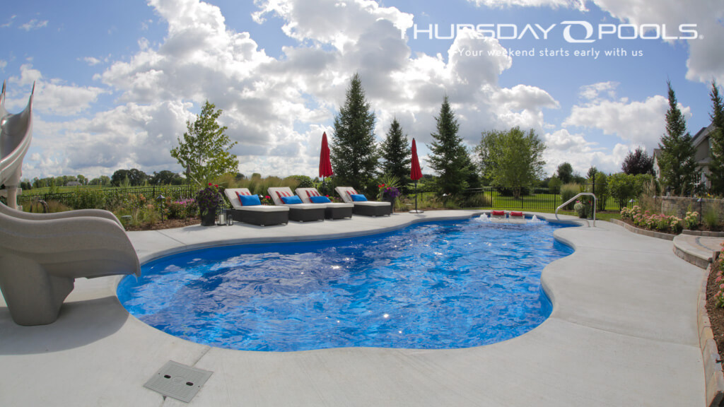 Installed Wellspring freeform fiberglass pool with slide and spa area