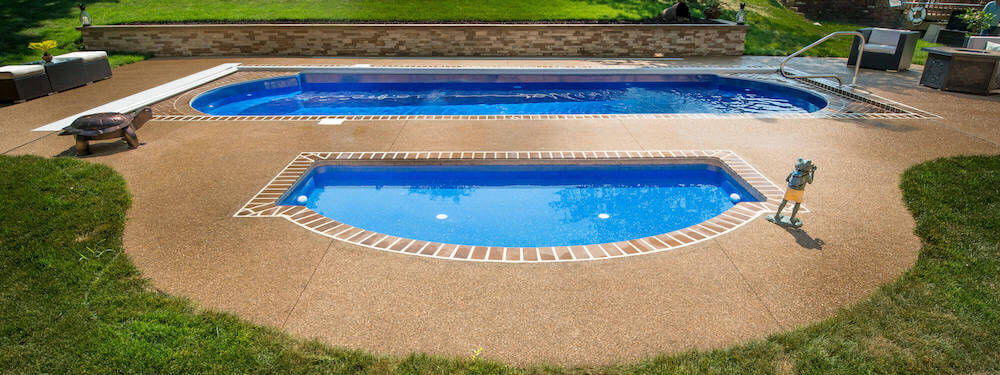 Installed Wet Deck tanning shelf paired with a Cathedral fiberglass pool