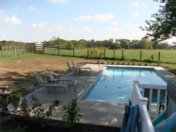 Vinyl liner inground pool with automatic safety cover and stamped concrete deck