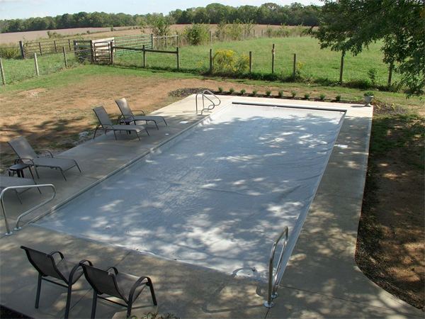 Vinyl liner inground pool with automatic safety cover and stamped concrete deck