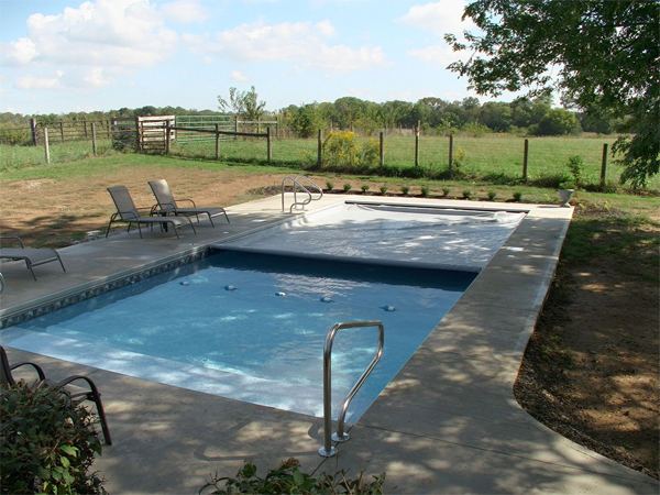 Vinyl liner inground pool with automatic safety cover and stamped concrete deck