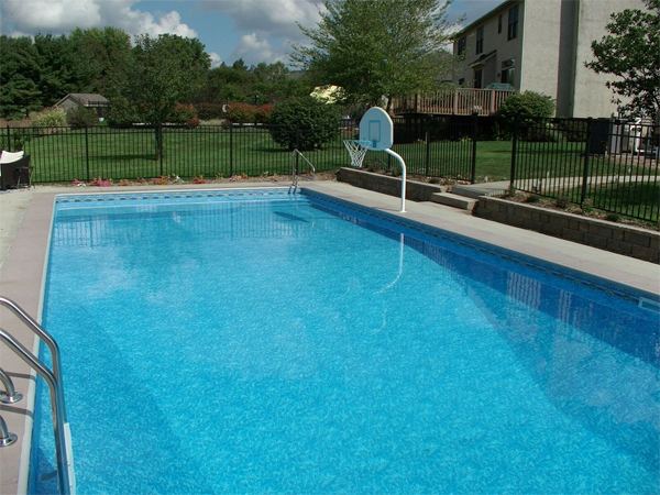 Vinyl liner inground pool with volleyball net and stamped concrete deck