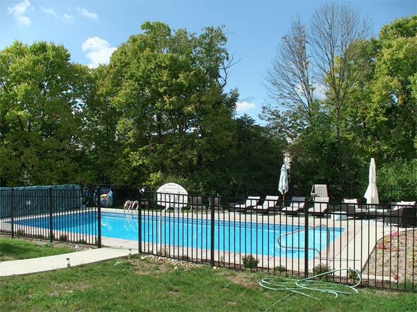 Vinyl liner inground pool with volleyball net and stamped concrete deck