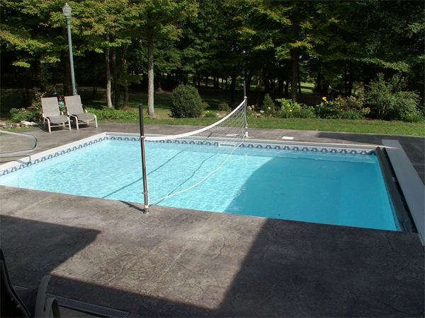 Fenced vinyl liner inground pool with patio seating area