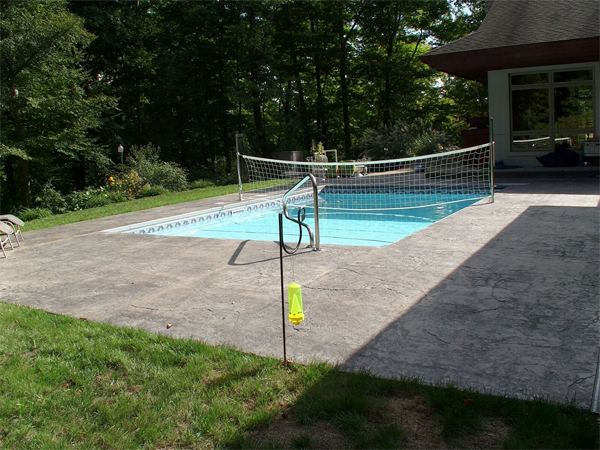 Fenced vinyl liner inground pool with patio seating area