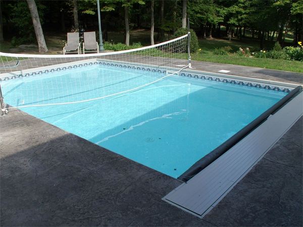 Fenced vinyl liner inground pool with patio seating area