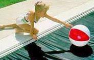 girl reaching for ball on pool cover