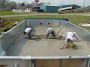 men leveling poured concrete
